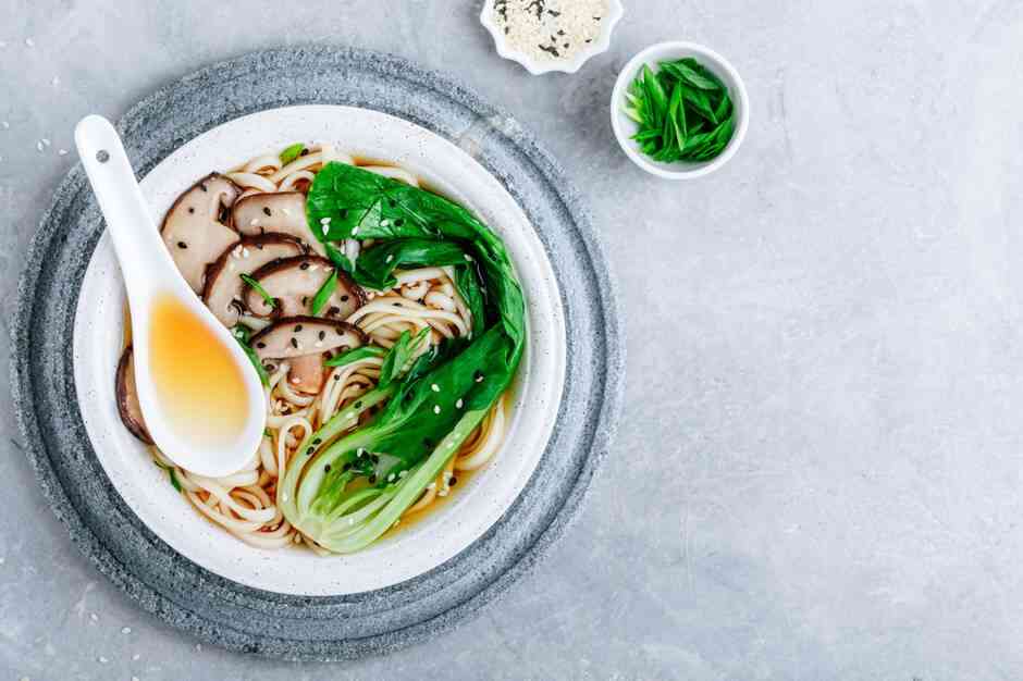 Azjatycka zupa wegetariańska Udon lub Ramen makaron w misce z grzybami Shiitake i Bok Choy